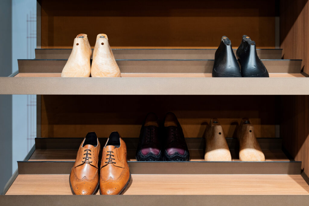 Leather shoes and wooden blocks on a wooden shelf